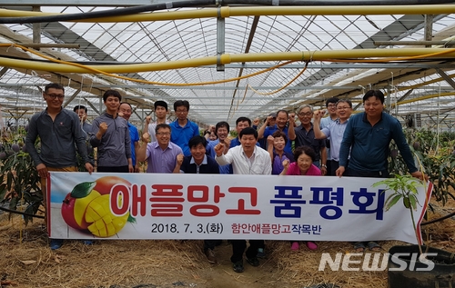 【함안=뉴시스】김기진 기자 = 3일 경남 함안애플망고작목반 회원, 함안군 농업기술센터 공무원, 지역농가 등 30여 명이 참석한 가운데 함안애플망고작목반(대표 김영석)이 한 농가에서 ‘기후변화 대응 열대과일 애플망고 품평회’를 가진 후 기념촬영을 하고 있다. 2018.07.04. (사진=함안군 제공) photo@newsis.com