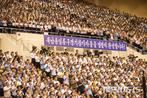 4일 평양 류경정주영체육관에서 개최된 남북통일농구경기에서 여자 ‘평화’팀과 ‘번영’팀이 혼합경기를 평양 주민들이 관람하며 응원하고 있다.