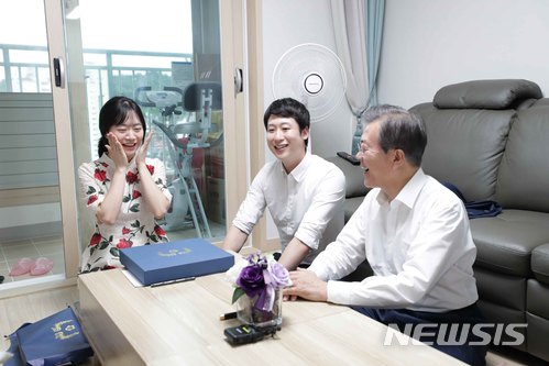 【서울=뉴시스】박진희 기자 = 문재인 대통령은 5일 서울 구로구 행복주택에 입주한 신혼부부 우재완(33)씨와 이진경(31)씨 가정을 방문해 신혼부부·청년 주거 문제에 대한 이야기를 나눴다. 문 대통령이 기념 벽걸이 시계를 선물하고 있다. 2018.07.05.pak7130@newsis.com