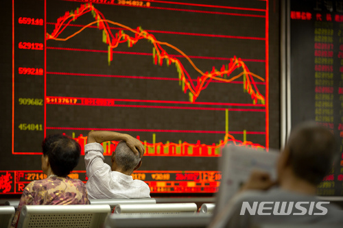 【베이징=AP/뉴시스】6일 중국 베이징의 한 증권사 객장에서 투자자가 전광판을 바라보고 있다. 미국은 이날 340억 달러(약 38조원) 규모의 중국산 제품에 25%의 관세를 부과하기 시작했지만 중국 증시가 상승 마감했다. 2018.07.06