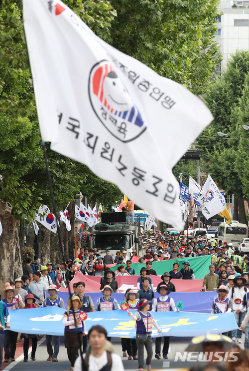 【서울=뉴시스】김진아 기자 = '법외노조 취소-노동3권 쟁취 전국교사결의대회'에 참가한 전국교직원노동조합 조합원들이 6일 오후 서울 종로구 사랑채 인근 도로에서 법외노조 통보 취소, 해고자 복귀, 교사의 노동3권 보장, 성과급·교원평가 폐지를 촉구하며 청와대를 향해 행진하고 있다. 2018.07.06. bluesoda@newsis.com