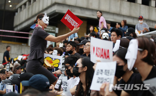 【서울=뉴시스】김진아 기자 = 6일 오후 서울 종로구 세종문화회관 앞 계단에서 열린 '아시아나항공 No Meal(노 밀) 사태 책임 경영진 규탄 문화제'에서 아시아나항공 승무원이 손팻말을 나눠주고 있다. 아시아나항공 승무원 등 직원들은 박삼구 회장에게 책임을 물으며 경영진 교체를 요구했다. 2018.07.06. bluesoda@newsis.com