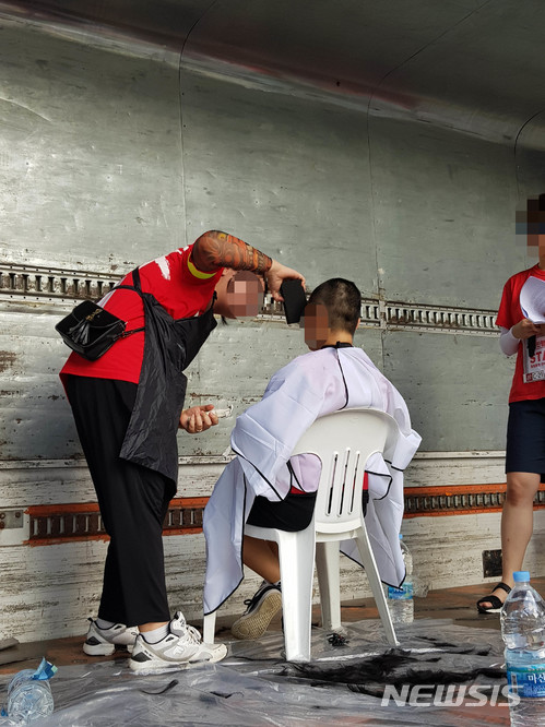 【서울=뉴시스】안채원 기자 = 7일 오후 서울 종로구 동숭동 혜화역~이화사거리에서 열린 '불법 촬영 편파수사' 3차 규탄집회에서 삭발식이 진행되고 있다. 2018.07.07.