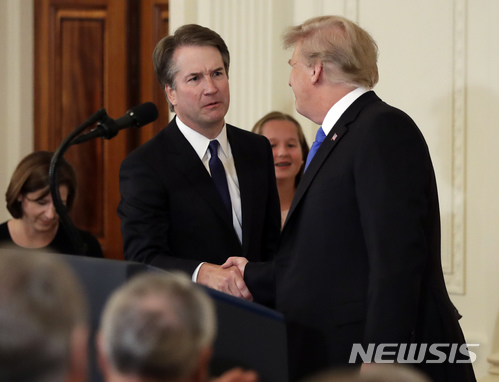 【 워싱턴=AP/뉴시스】도널드 트럼프 미국 대통령이 9일(현지시간) 워싱턴 백악관 이스트룸에서 연방대법관에 브렛 캐배너 판사를 지명한 후 악수하고 있다.2018.07.10
