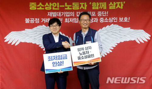 【서울=뉴시스】임태훈 기자 = 지난달 10일 오전 서울 중구 전국민주노동조합총연맹 대회의실에서 열린 민주노총, 한국중소상인자영업자총연합회 주최로 열린 노동자·중소상인 '함께 살자' 공동 기자회견을 마친 김명환(오른쪽) 민주노총 위원장과 인태연 한상총련 상임회장이 손팻말을 들고 악수하고 있다. 2018.07.10.  taehoonlim@newsis.com