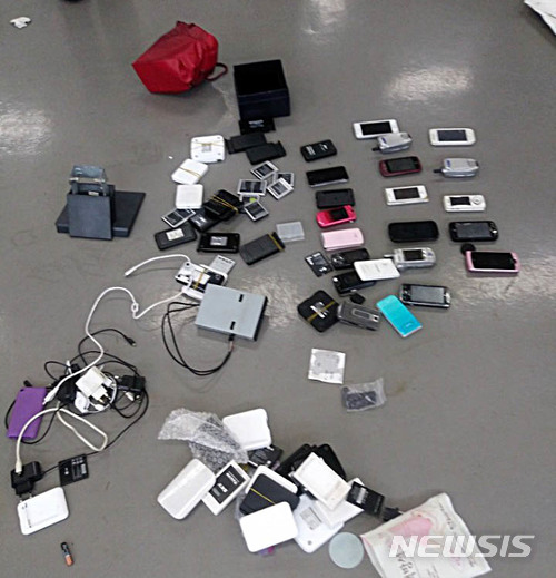 【서울=뉴시스】최득신 특별검사보 등 수사팀 7명이 10일 오후 경기도 파주 느릅나무 출판사 사무실 1층 현장 쓰레기더미 안에서 발견한 휴대폰 21대와 유심칩을 발견해 공개 했다. 2018.07.10. (사진= 특검팀 제공)photo@newsis.com