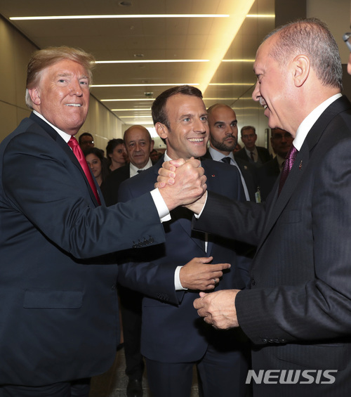  【브뤼셀(벨기에)=AP/뉴시스】도널드 트럼프 미 대통령(왼쪽)이 11일 벨기에 브뤼셀의 나토(북대서양조약기구) 본부에서 열리고 있는 나토 정상회담 도중 에마뉘엘 마크롱 프랑스 대통령(가운데)이 지켜보는 가운데 레제프 타이이프 에르도안 터키 대통령과 악수하고 있다. 2018.7.12 