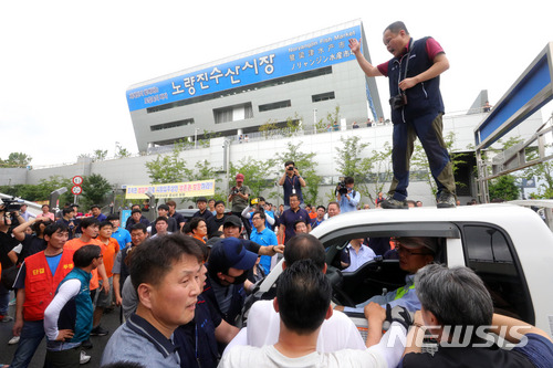 【서울=뉴시스】배훈식 기자 = 서울중앙지법이 구 노량진수산시장 불법 점유 상점에 대한 명도집행에 들어간 12일 오전 서울 동작구 구 시장 앞에서 상인들이 집행관들과 대치하고 있다. 2018.07.12. dahora83@newsis.com