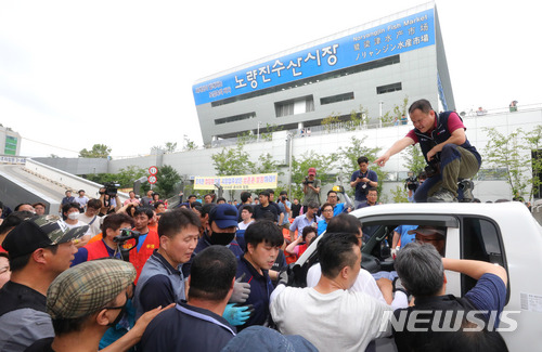 【서울=뉴시스】배훈식 기자 = 서울중앙지법이 구 노량진수산시장 불법 점유 상점에 대한 명도집행에 들어간 12일 오전 서울 동작구 구 시장 앞에서 상인들이 집행관들과 대치하고 있다. 2018.07.12. dahora83@newsis.com