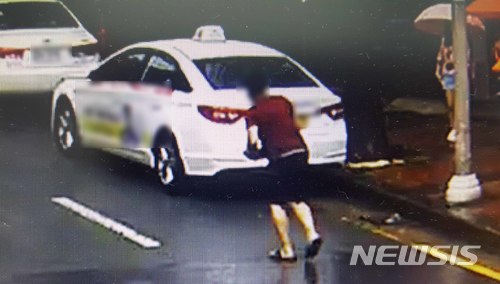 【부산=뉴시스】 하경민 기자 = 부산 영도경찰서는 13일 도로에 떨어진 현금 500만원 상당이 든 손가방을 가져간 A(34)씨를 점유이탈물횡령 혐의로 불구속 입건했다고 밝혔다.사진은 지난 3일 제7호 태풍 '쁘라삐룬'의 영향으로 비바람이 몰아쳤지만 우산도 없이 도로로 걸어와 손가방을 줍는 A씨의 모습. 2018.07.13. (사진=영도경찰서 제공)yulnetphoto@newsis.com