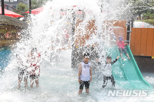 【울산=뉴시스】배병수 기자 = 울산지역에 폭염경보가 발효된 13일 울산시 중구 우정동 물놀이장을 찾은 아이들이 물 폭포를 맞으며 더위를 식히고 있다. 2018.07.13.&nbsp;&nbsp;&nbsp; bbs@newsis.com.