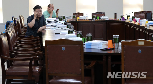 【세종=뉴시스】강종민 기자 = 13일 오후 정부세종청사에서 속개된 최저임금위원회 전원회의가 또다시 정회한 가운데 근로자위원들이 굳은 표정으로 전화통화를 하며 사용자위원들의 복귀를 기다리고 있다. 2018.07.13.&nbsp;&nbsp; ppkjm@newsis.com