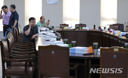 【세종=뉴시스】강종민 기자 = 13일 오후 정부세종청사에서 속개된 최저임금위원회 전원회의가 또다시 정회한 가운데 근로자위원들이 굳은 표정으로 전화통화를 하며 사용자위원들의 복귀를 기다리고 있다. 2018.07.13.&nbsp;&nbsp; ppkjm@newsis.com