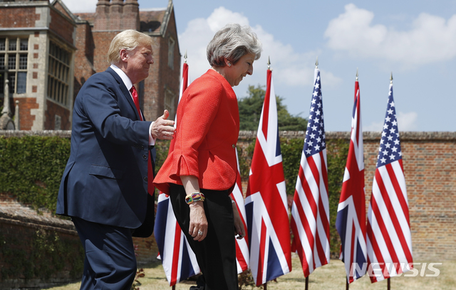 【체커스=AP/뉴시스】 영국 방문중인 도널드 트럼프 대통령이 13일 영국 총리의 체커스 시골별장에서 메이 총리와 오찬 정상회담을 가진 뒤 기자회견을 하기 위해 별장 뜰로 내려오고 있다. 트럼프는 전날 인터뷰 내용을 부인하며 메이 총리를 칭찬했다. 2018. 7. 13. 