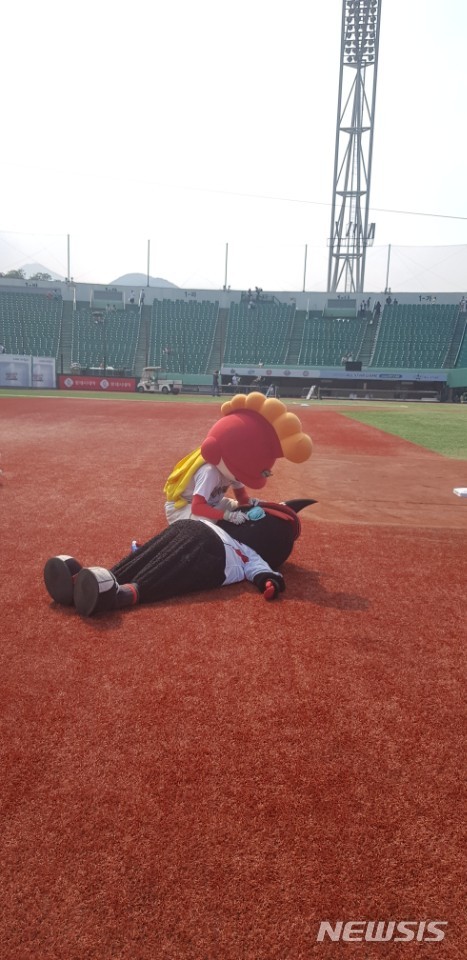 【울산=뉴시스】 14일 올스타전이 열린 울산 문수야구장에서 그라운드에 누워 더위를 표현하고 있는 KT 위즈의 마스코트 빅또리와 돌봐주는 시늉을 하는 SK 와이번스 마스코트 아테나. 2018.07.14. jinxijun@newsis.com