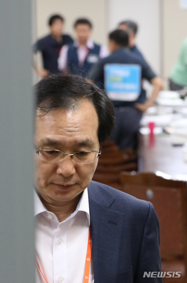 【세종=뉴시스】강종민 기자 = 14일 새벽 정부세종청사에서 열린 최저임금위원회 전원회의가 정회되자 류장수 위원장이 굳은 표정으로 회의장 밖으로 빠져나오고 있다. 뒤쪽은 얘기 나누는 근로자위원들. 2018.07.14.&nbsp; ppkjm@newsis.com