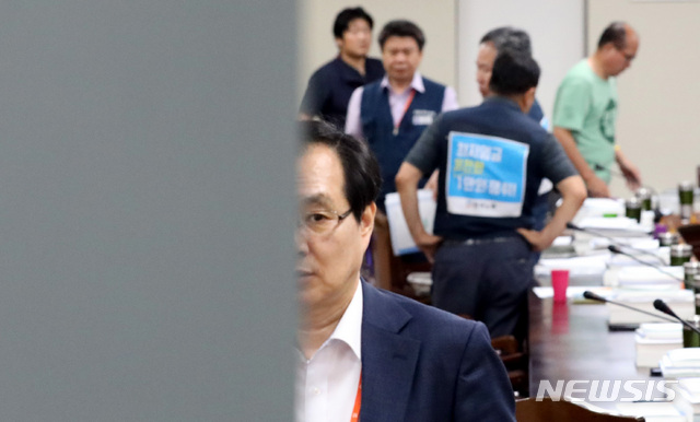 【세종=뉴시스】강종민 기자 = 14일 새벽 정부세종청사에서 열린 최저임금위원회 전원회의가 정회되자 류장수 위원장이 회의장 밖으로 나오고 있다. 뒤쪽은 얘기 나누는 근로자위원들. 2018.07.14.&nbsp; ppkjm@newsis.com