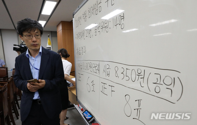 【세종=뉴시스】강종민 기자 = 14일 새벽 정부세종청사에서 열린 최저임금위원회 전원회의에서 2019년 최저임금이 8350원으로 결정된 가운데 공익위원이 표결결과를 보고 있다. 2018.07.14.&nbsp; ppkjm@newsis.com