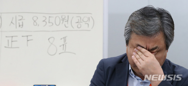 【세종=뉴시스】강종민 기자 = 14일 새벽 정부세종청사에서 2019년 최저임금 의결을 마친 뒤 가진 브리핑에서 공익위원이 피곤한 듯 얼굴을 만지고 있다. 이날 열린 회의에서 2019년 최저임금은 8350원으로 의결됐다. 2018.07.14.&nbsp; ppkjm@newsis.com