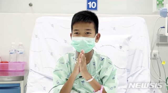 【치앙라이=AP/뉴시스】태국 북부 치앙라이 탐루엉 동굴에서 고립됐다 구조된 소년들 및 코치 등 13명이 입원 중인 '치앙라이 쁘라차눅로' 병원에서 영상을 통해 전 세계에 감사 인사를 전했다. 영상은 지난 13일 촬영된 것으로, 소년 1명이 손을 합장하고 감사 인사를 전하고 있다. 2018.07.14. 