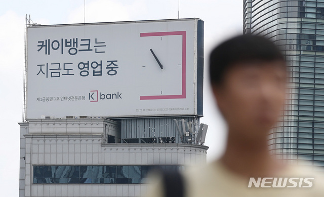 【서울=뉴시스】김진아 기자 = 국내 1호 인터넷전문은행 케이뱅크의 1500억원 유상증자가 난항을 겪으며 출범 이후 최대 위기에 봉착했다. 15일 금융계에 따르면 케이뱅크는 지난 12일 당초 1500억원으로 결의했던 유상증자에 일부 주주들이 불참해 300억만 우선 납입됐다. 이번 유상증자가 실패로 끝날 경우 케이뱅크는 대규모 자본확충 불가로 자금난을 겪게 되고 결국 외형성장도 물건너 갈 우려가 높은 것으로 지적된다. 사진은 서울 종로구 광화문 일대에 설치된 케이뱅크 광고판. 2018.07.15.&nbsp; bluesoda@newsis.com