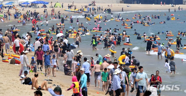【부산=뉴시스】 하경민 기자 = 15일 오후 부산 해운대해수욕장을 찾은 시민과 관광객들이 물놀이를 즐기고 있다. 부산에는 지난 11일 폭염주의보가 발령됐다가 12일 경보로 대치돼 나흘 동안 유지되고 있다. 2018.07.15. yulnetphoto@newsis.com
