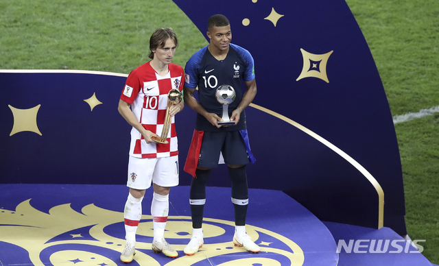 Croatia's Luka Modric and France's Kylian Mbappe, right, pose with their individual awards at the end of the final match between France and Croatia at the 2018 soccer World Cup in the Luzhniki Stadium in Moscow, Russia, Sunday, July 15, 2018. (AP Photo/Thanassis Stavrakis)