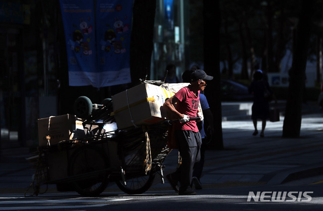 【서울=뉴시스】임태훈 기자 = 가마솥 무더위가 이어지고 있는 16일 오전 서울 종로구 서울시청 인근 무교로에서 한 노인이 폐지를 가득싫은 리어카를 끓고 있다. 2018.07.16.&nbsp; taehoonlim@newsis.com