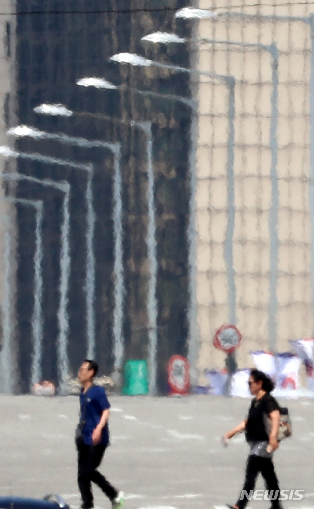 【서울=뉴시스】박주성 기자 = 서울에 올해 첫 폭염경보가 발효된 가운데 16일 오후 아지랑이가 피어오르는 서울 여의도 아스팔트 위를 시민들이 걷고 있다. 2018.07.16. park7691@newsis.com