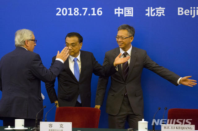 【베이징=AP/뉴시스】리커창 중국 총리(가운데)가 16일 베이징 인민대회당장에서 열린 중국-EU 비즈니스 라운드테이블을 마친 후 장 클로드 융커 유럽연합집행위원장(왼쪽)에게 길을 안내하고 있다. 2018.07.16