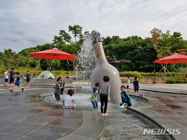 【영동=뉴시스】이성기 기자 = 지난 16일 오후 충북 영동군 영동읍 과일나라테마공원 내 와인병 분수에서 어린이들이 물놀이를 하고 있다.2018.07.17(사진=영동군 제공) photo@newsis.com