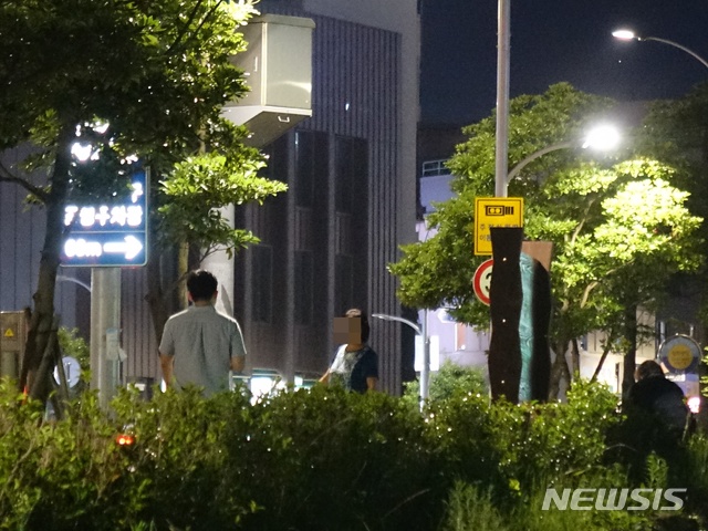 【제주=뉴시스】조수진 기자 = 지난 16일 오후 제주시 일도1동 산지천 일대에서 한 중년 여성(가운데)이 남성인 기자를 상대로 불법 성매매 호객행위를 하고 있다. 사진 오른쪽에 또 다른 여성이 화단에 걸터앉아 사람이 지나가길 기다리고 있다. 2018.07.16.&nbsp; susie@newsis.com