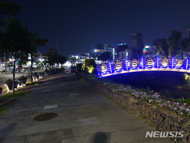 【제주=뉴시스】조수진 기자 = 16일 오후 제주시 일도1동 산지천 산책로 풍경. 지나는 사람은 없고 화려한 조명으로 꾸며진 다리만 휑하니 놓여있다. 멀리 밝게 빛나는 곳은 동문재래시장 입구이다. 2018.07.16. susie@newsis.com