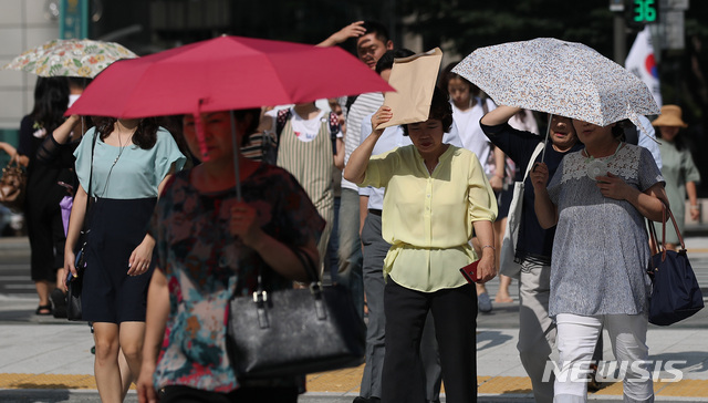 【서울=뉴시스】김진아 기자 = 찜통더위가 이어진 18일 오전 서울 종로구 광화문 네거리에서 시민들이 내리쬐는 햇볕을 가리며 출근하고 있다. 2018.07.18.&nbsp;&nbsp; bluesoda@newsis.com