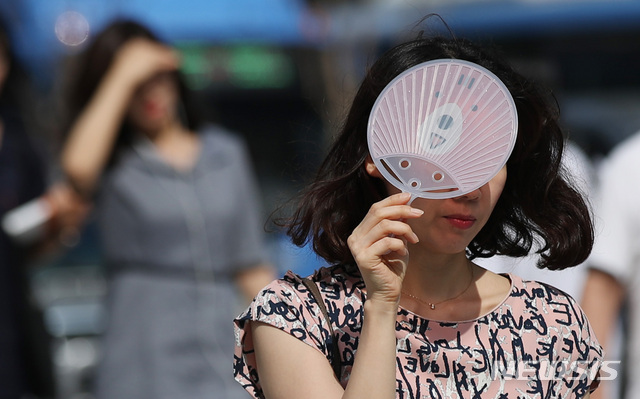 【서울=뉴시스】김진아 기자 = 찜통더위가 이어진 18일 오전 서울 종로구 광화문 네거리에서 시민들이 내리쬐는 햇볕을 가리며 출근하고 있다. 2018.07.18.&nbsp; bluesoda@newsis.com