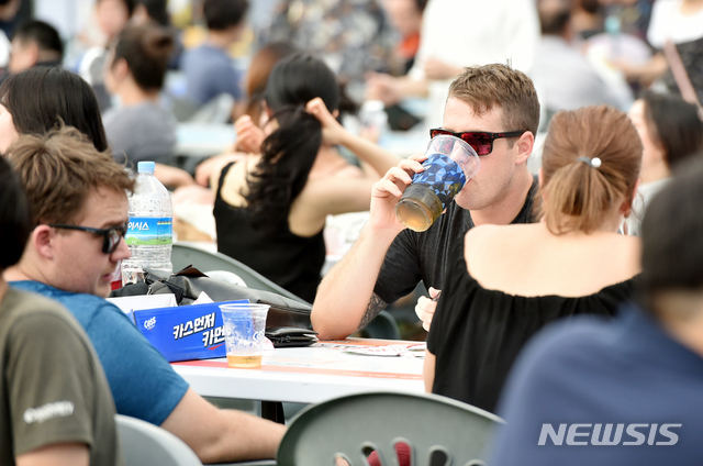 【대구=뉴시스】우종록 기자 = 18일 오후 대구시 달서구 두류공원 일대에서 열린 ‘2018 대구 치맥페스티벌’ 행사장을 찾은 관광객이 시원한 맥주와 다양한 치킨을 맛보며 축제를 즐기고 있다. 2018.07.18. wjr@newsis.com