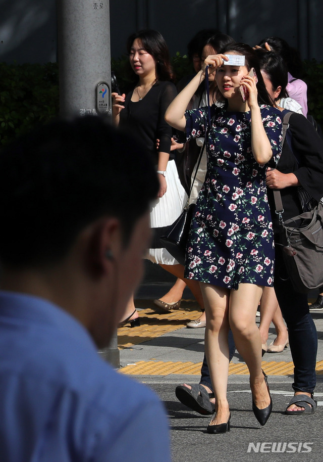 【서울=뉴시스】배훈식 기자 = 대구 낮 최고기온 37도 등 전국에 폭염특보가 이어진 19일 오전 서울 종로구 외교부 청사 후문 횡단보도에서 시민들이 햇빛을 가리며 출근길 발걸음을 재촉하고 있다. 2018.07.19. dahora83@newsis.com