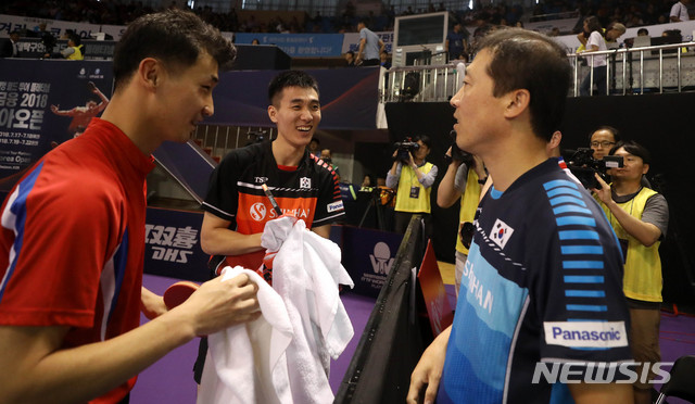 【대전=뉴시스】추상철 기자 = 2018 코리아오픈 탁구대회가 열린 19일 오후 대전 충무체육관에서 남자복식 본선 16강에 출전한 남북단일팀 이상수(남측)-박신혁이 독일-슬로바키아 단일팀을 상대로 승리를 거둔후 김택수 감독과 함께 활짝 웃고 있다. 2018.07.19. scchoo@newsis.com