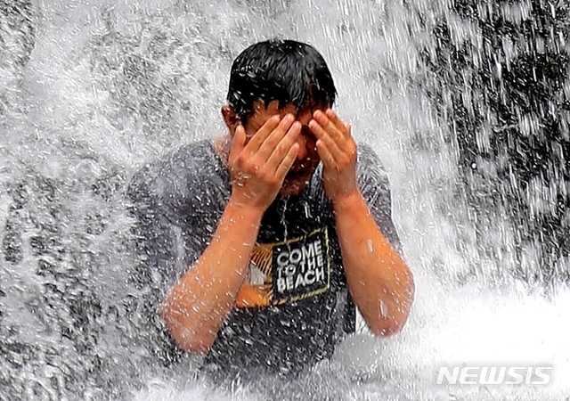 【제주=뉴시스】우장호 기자 = 폭염특보가 계속된 지난 15일 제주 서귀포시 상효동 돈내코 계속 원앙폭포에서 한 시민이 폭포수를 맞으며 더위를 식히고 있다. 2018.07.20. (사진=뉴시스DB) woo1223@newsis.com