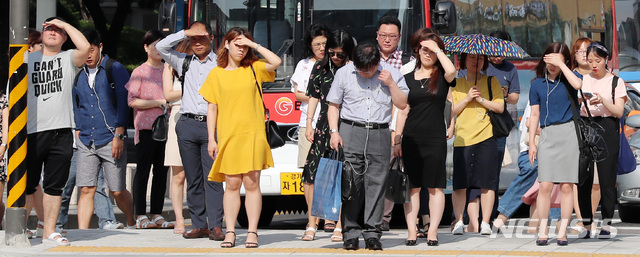 【서울=뉴시스】이영환 기자 = 폭염 경보가 이어지고 있는 20일 오전 서울 종로구 광화문 네거리에서 시민들이 따가운 햇빛을 손으로 가리며 신호를 기다리고 있다. 2018.07.20.&nbsp; 20hwan@newsis.com