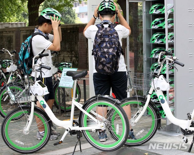 【서울=뉴시스】고범준 기자 = 서울시설공단이 지난 19일 공공자전거 '따릉이'를 이용할 때 안전모 무료 대여 사업을 한 달간 시범 운영한다고 밝혔다. 따릉이 이용자들의 안전모 착용이 의무화되는 9월을 앞두고 여의도 지역 따릉이 대여소 30곳에서 안전모 500개를 시범 대여해 준다. 사진은 20일 오후 서울 영등포구 여의나루역 인근 안전모 보관소 앞에서 시민들이 따릉이와 안전모를 이용하는 모습. 2018.07.20. bjko@newsis.com