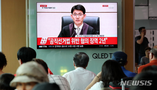【서울=뉴시스】이영환 기자 = 국정원 특활비 뇌물 수수 혐의와 공천 개입 혐의로 구속된 박근혜 전 대통령의 선고 공판이 열린 20일 오후 서울 용산구 서울역 대합실에서 시민들이 중계방송을 시청하고 있다.박근혜 전 대통령은 이날 선고공판에서 국고손실·공천개입 각 6년·2년을 선고 받았다. 2018.07.20.&nbsp; 20hwan@newsis.com