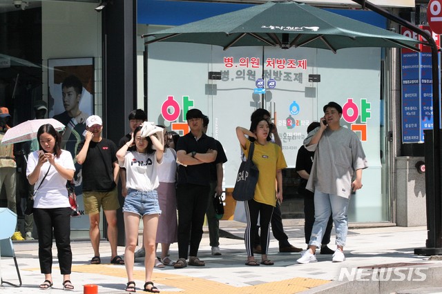 【춘천=뉴시스】박종우 기자 = 21일 오후 강원 춘천시 운교동의 한 교차로에서 시민들이 무더위를 피해 그늘막 아래 모여 있다. 2018.07.21 jongwoo425@newsis.com