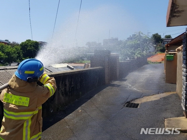 【속초=뉴시스】김경목 기자 = 폭염이 기승을 부린 22일 강원 속초소방서 소방관이 속초시의 한 취약계층 마을 골목길에서 물을 뿌려 열기를 식히고 있다.&nbsp; 속초소방서는 "취약계층을 보호하기 위해서 7월21일부터 폭염주의보 시 1회 이상 폭염경보 시 2회 이상 소화전과 소방차를 활용해 물을 뿌려 폭염의 열기를 식히고 있다"고 밝혔다. 2018.07.22. (사진=속초소방서 제공) photo@newsis.com