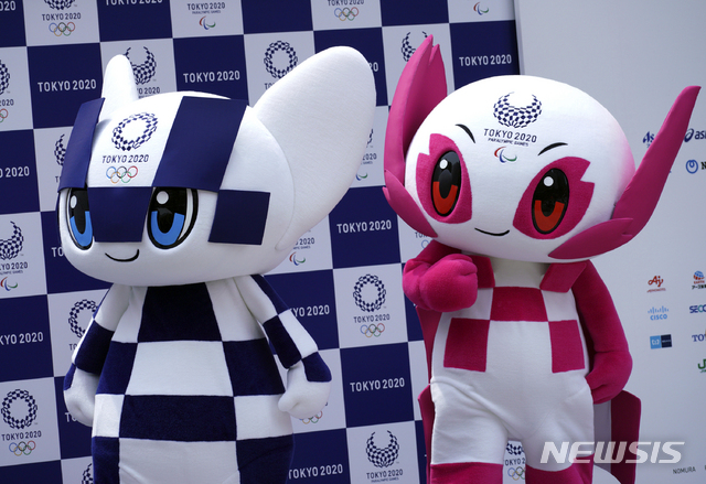 Tokyo 2020 Olympic mascot "Miraitowa", left, and Paralympic mascot "Someity", right, stand at stage during their debut event in Tokyo Sunday, July 22, 2018. The official mascots for the Tokyo 2020 Olympics and Paralympics were unveiled at a ceremony on Sunday. The two mascot designs were selected by elementary schoolchildren across Japan. (AP Photo/Eugene Hoshiko)
