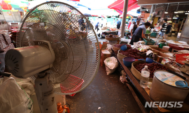 【서울=뉴시스】김진아 기자 = 서울을 비롯한 전국 대부분의 지역에 폭염 특보가 발효된 22일 서울 동대문구 경동시장에서 상인들이 더위를 식히기 위해 선풍기를 틀어놓고 있다. 2017.07.22. bluesoda@newsis.com