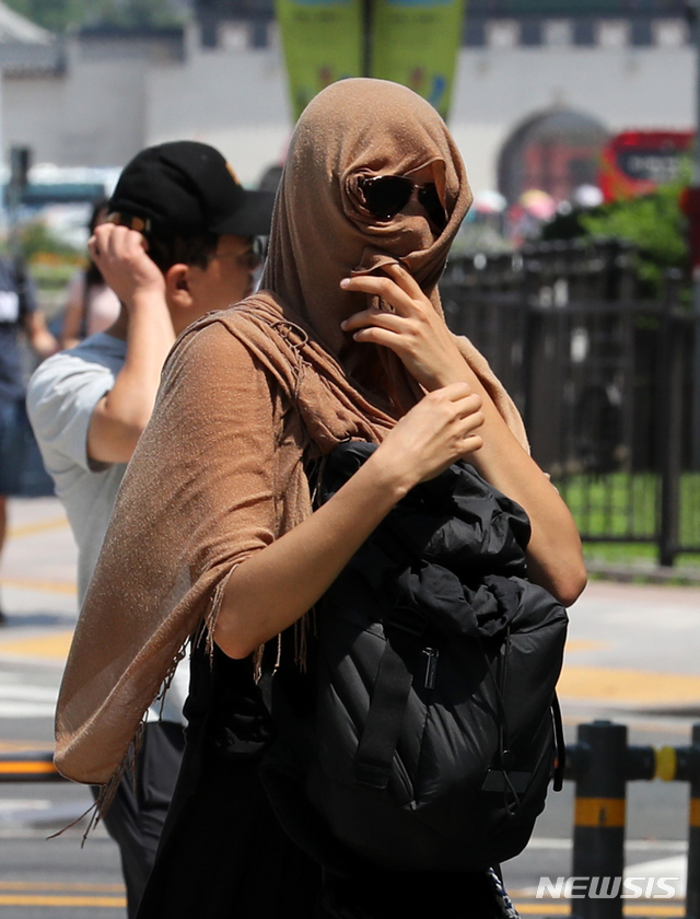 【서울=뉴시스】박진희 기자 = 전국적으로 폭염 경보가 발효중인 22일 오전 서울 종로구 광화문 사거리에서 한 여성이 뜨거운 햇볕을 피해 얼굴을 가리고 있다.&nbsp; 기상청은 오늘 서울 낮 기온 37도로 하루 만에 또다시 최고 기온을 경신할 것으로 예보했다. 2018.07.22.&nbsp; pak7130@newsis.com