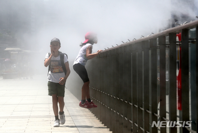 【서울=뉴시스】박진희 기자 = 전국적으로 폭염 경보가 발효중인 22일 오전 서울 종로구 광화문광장에서 물안개를 분사하는 쿨링포그 앞에서 외국인 관광객 어린이들이 더위를 식히고 있다.&nbsp; 기상청은 오늘 서울 낮 기온 37도로 하루 만에 또다시 최고 기온을 경신할 것으로 예보했다. 2018.07.22.&nbsp; pak7130@newsis.com