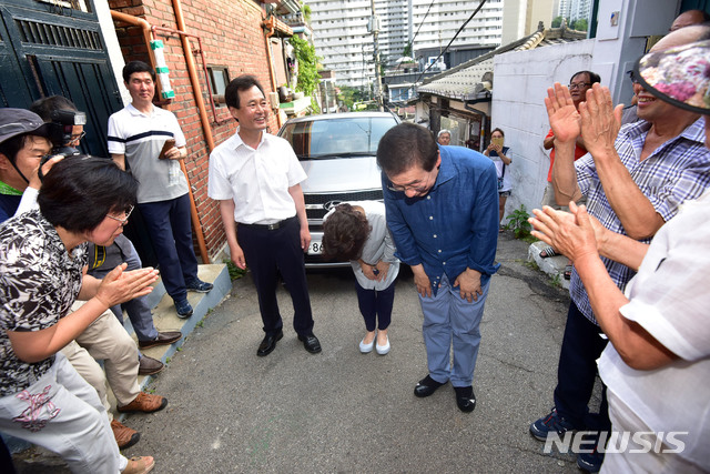 【서울=뉴시스】사진공동취재단 = 박원순 서울시장이 22일 오후 강북 '한 달 살이'를 시작하는 강북구 삼양동의 2층 옥탑방에 도착해 지역주민들에게 인사하고 있다. 박 시장은 조립식 건축물 2층 옥탑방(방 2개, 9평(30.24㎡))에서 다음 달 18일까지 기거하면서 지역 문제의 해법을 찾고 강남·북 균형발전을 방안을 모색한다. 2018.07.22. photo@newsis.com