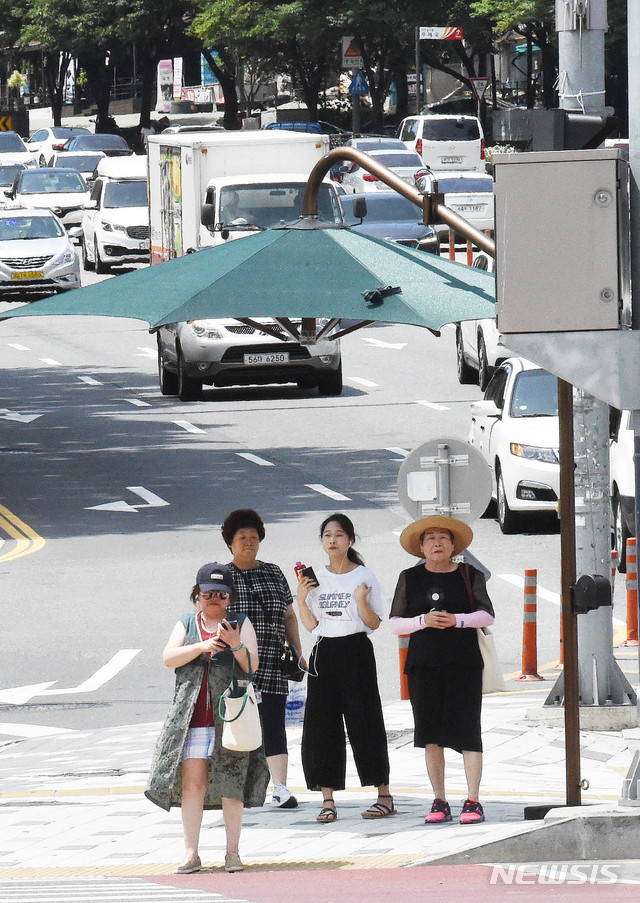 【대전=뉴시스】함형서 기자 =전국적으로 폭염경보가 발효된 23일 오후 대전 서구 둔산동사거리 앞에서 신호등 앞에 설치된 그늘막 안에서 시민들이 신호를 기다리고 있다. 2018.07.23.foodwork23@newsis.com